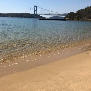 A beach with clear water and a bridge in the background. - Washuzan Shimoden Hotel (Kurashiki)