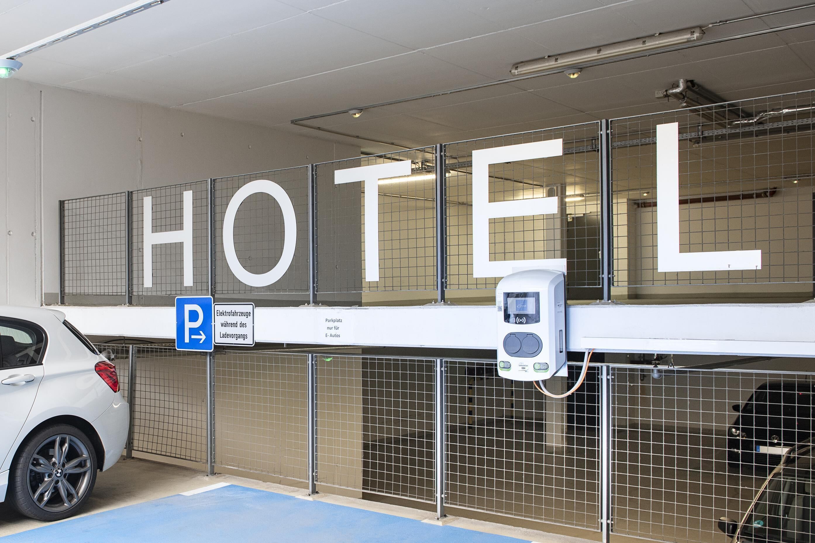 A hotel parking area with a sign indicating electric vehicle charging.