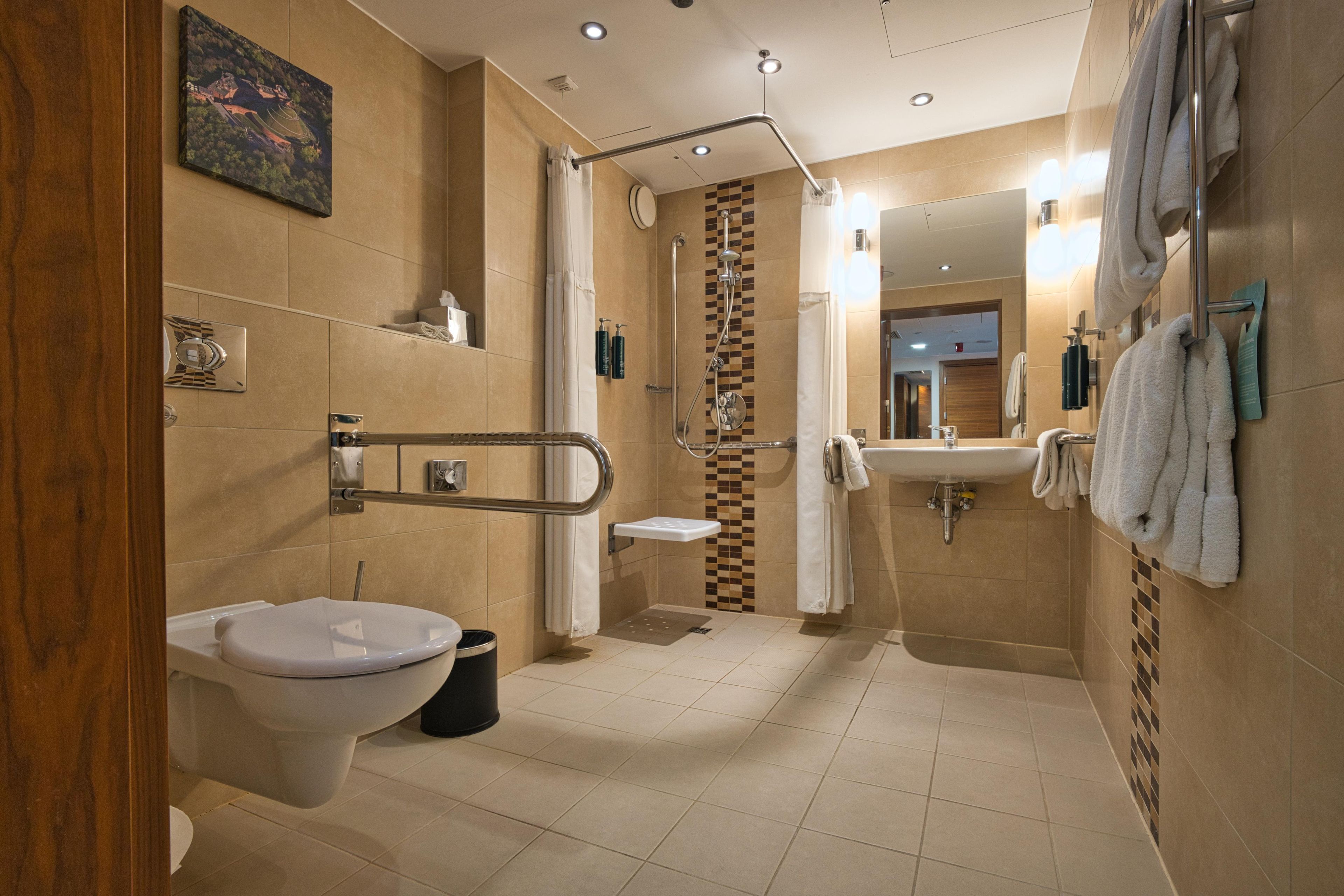 A modern bathroom with a toilet, bidet, sink, and shower.
