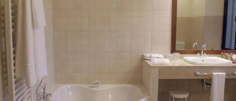 A modern bathroom with a freestanding bathtub, a vanity with a mirror, and a toilet.