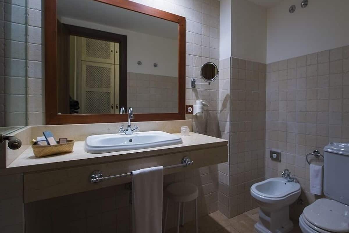 Ein Badezimmer mit Waschbecken, Spiegel, Bidet und Toilette.