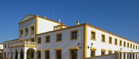 Un edificio blanco con detalles amarillos y un balcón, con la leyenda 'Hotel Cortez S.A. Campos'.