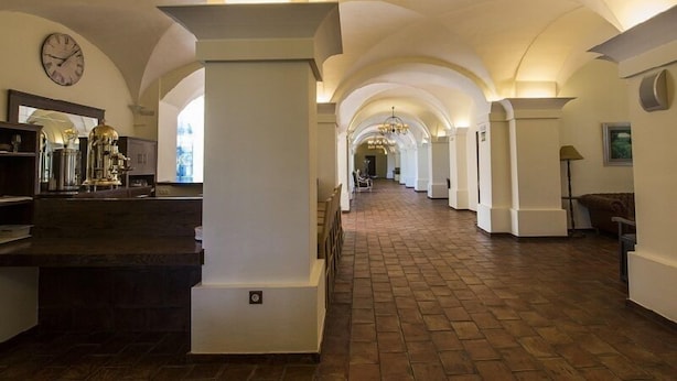 A hallway with arched ceilings, a clock, and a chandelier. - Hospedium Hotel Cortijo Santa Cruz (Villanueva de la Serena)