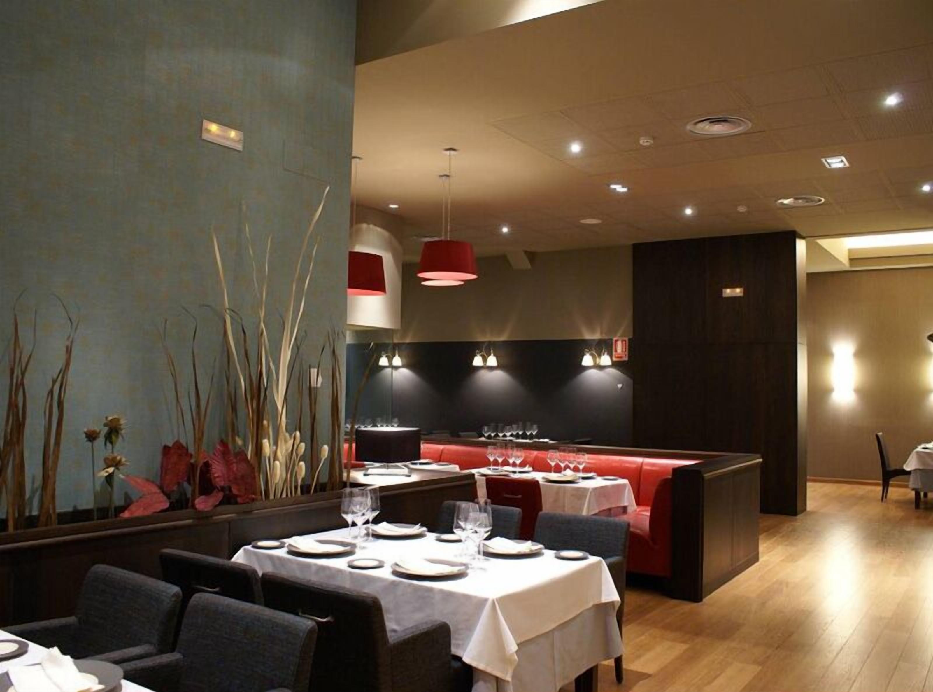 A restaurant with tables set for dining, a bar area, and a seating section.