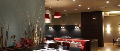 A restaurant with tables set for dining, a bar area, and a seating section.