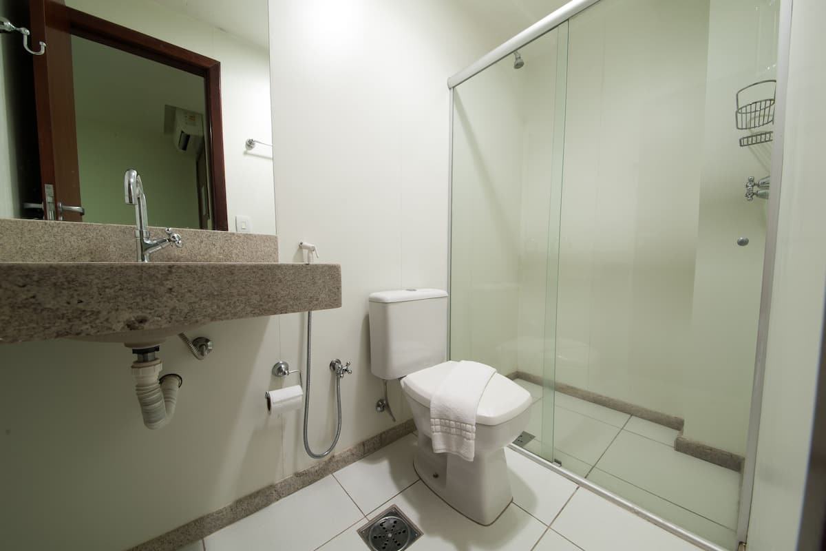 A bathroom with a sink, toilet, and glass-enclosed shower.