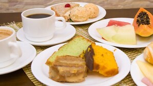 A breakfast table with various food items, including pastries, fruit, and beverages. - Premium Executive Hotel (Itabira)