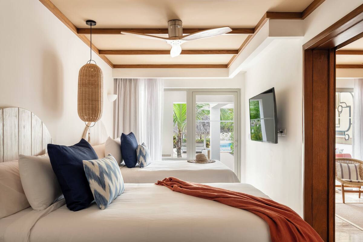 Un dormitorio con una cama grande, un ventilador de techo y vistas al exterior.
