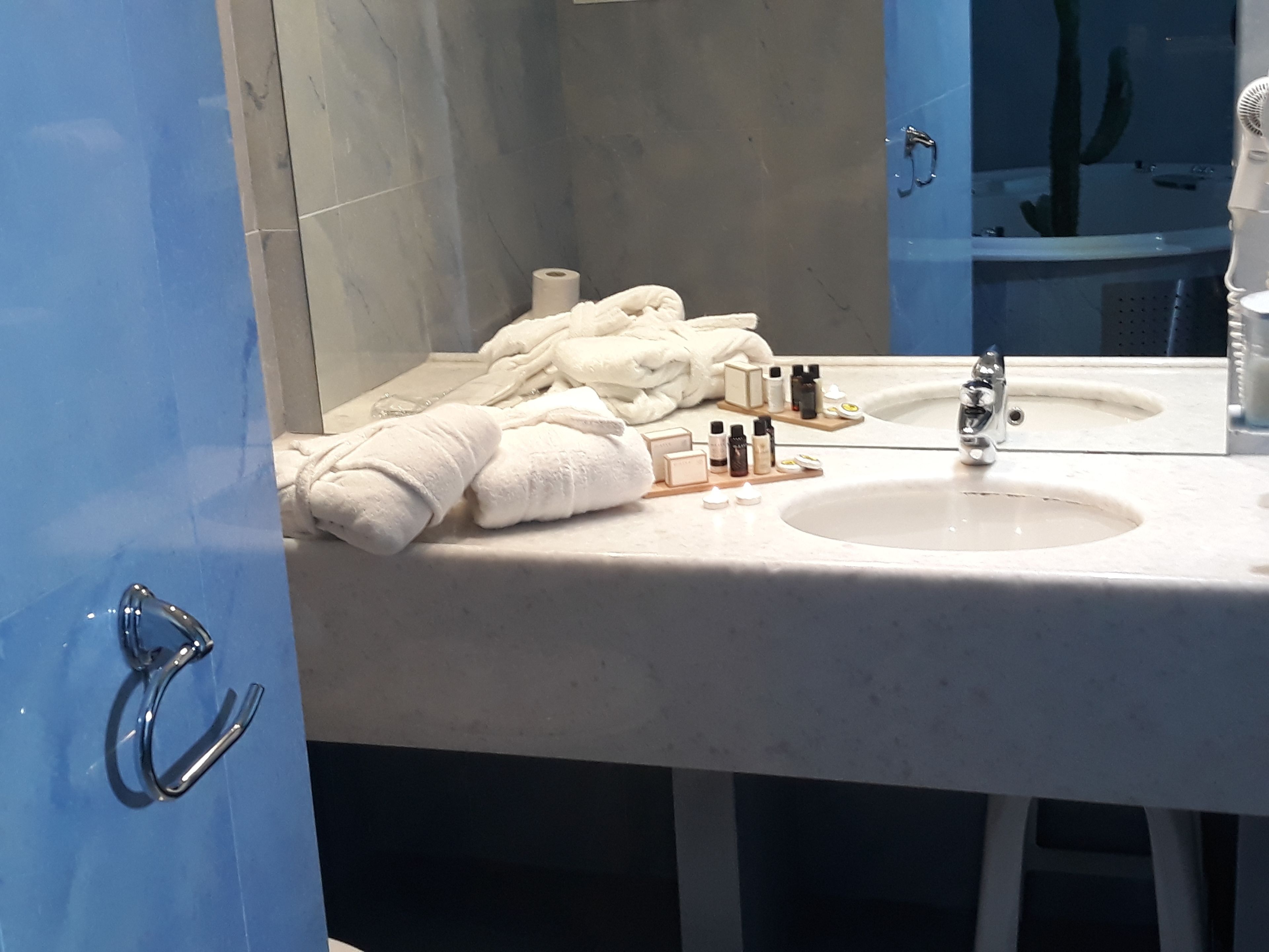 Un baño con dos lavamanos, un espejo y un perchero para toallas.