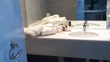 Un baño con dos lavamanos, un espejo y un perchero para toallas.
