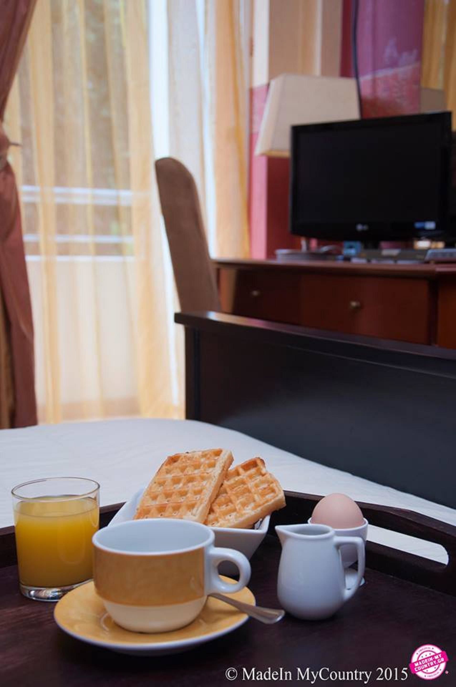 A breakfast setup with waffles, a cup of coffee, a glass of orange juice, and an egg on a tray.