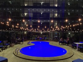 Una piscina al aire libre, sombrillas, sillones reclinables de piscina