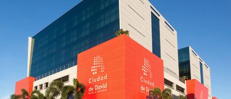 A modern hotel with a red and white facade, featuring the name 'Ciudad de David' prominently displayed.