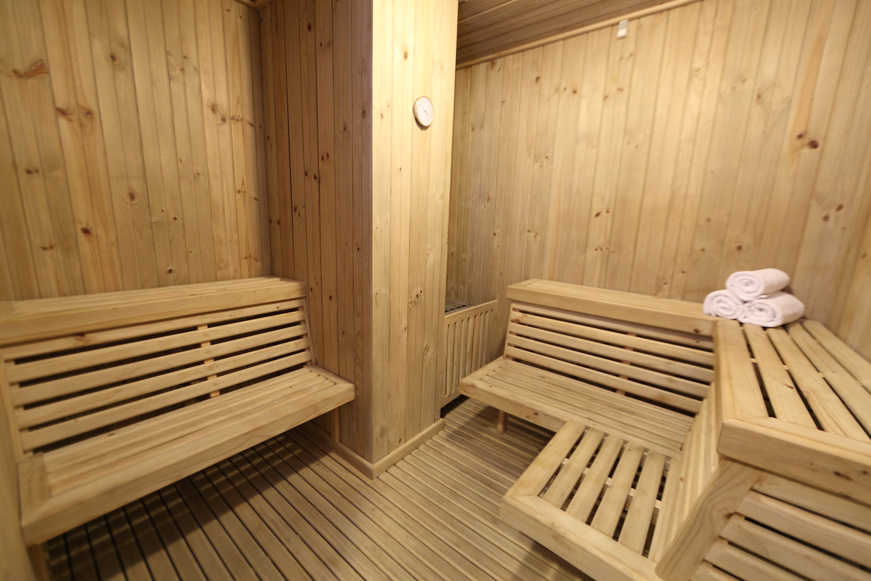 Una sauna in legno con panche e un tavolo con asciugamani.