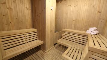Uma sauna de madeira com bancos e uma mesa com toalhas.