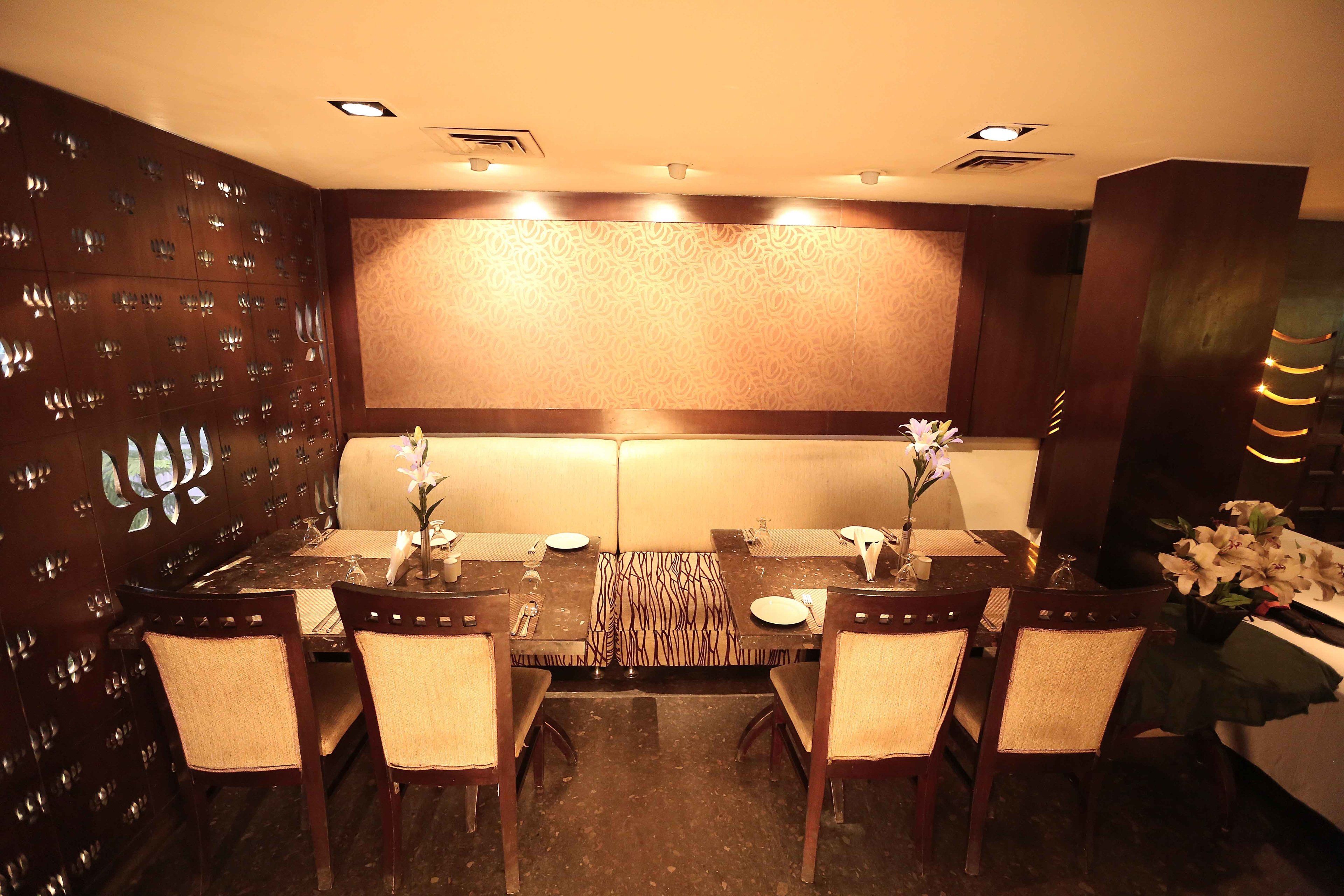 Un espace repas avec une longue table, six chaises et un mur décoré de motifs.