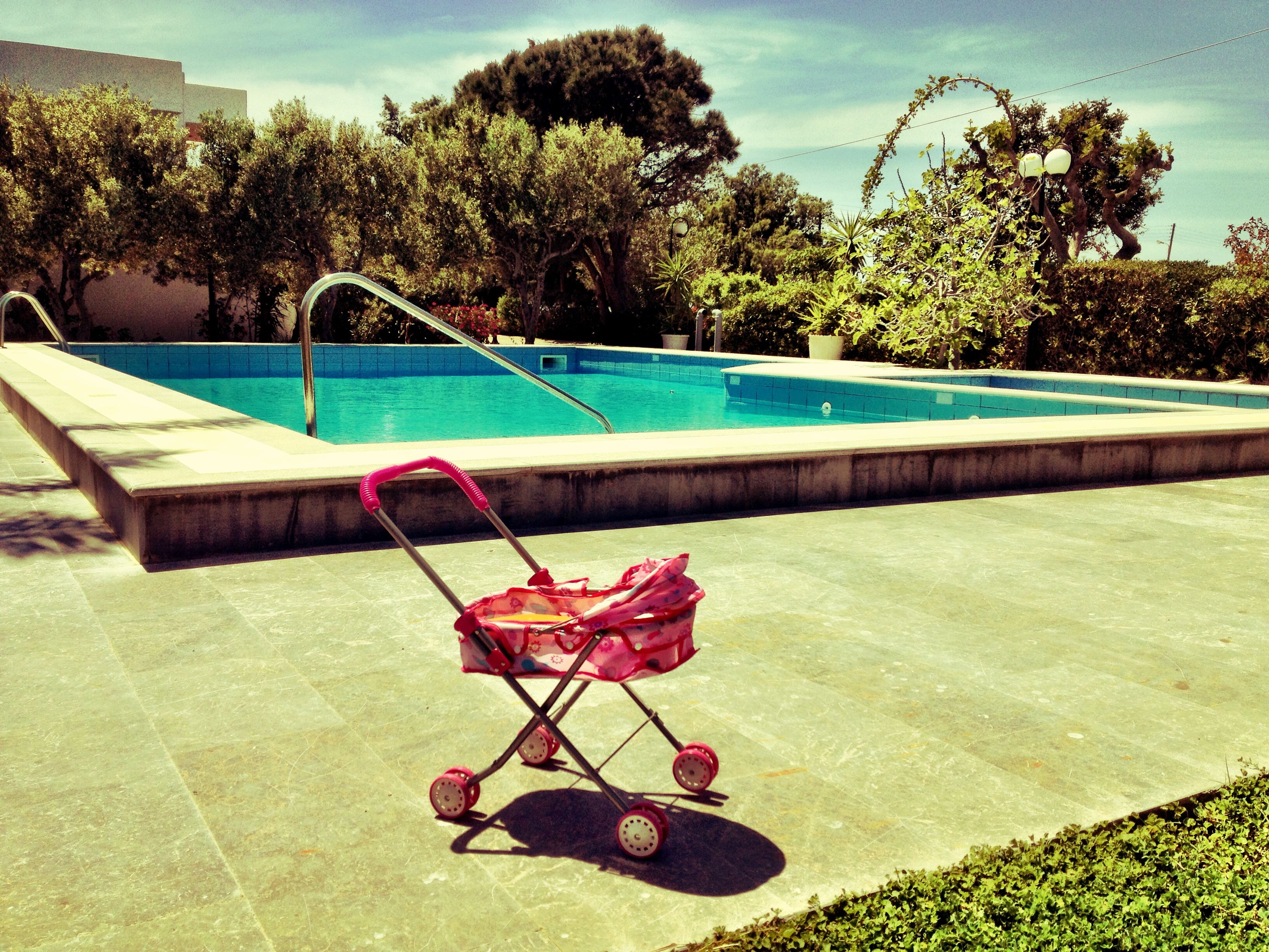 Piscina com um carrinho de bebê em primeiro plano.