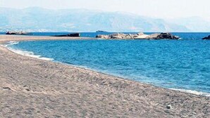 A beach with clear blue water, rocky outcrops, and distant mountains. - Irene Villas (Ierapetra)