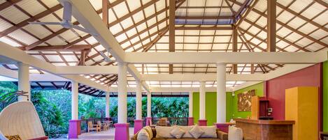 A spacious lobby with a high ceiling, large windows, and a reception desk.