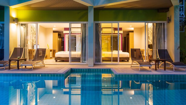 A modern hotel with a pool area, two bedrooms with sliding doors, and lounge chairs. - Panalee Koh Samui Resort (Koh Samui)