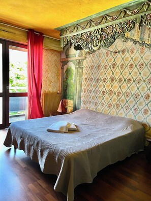 A room with a large bed, a window with red curtains, and a patterned wallpaper. - Hotel de la Gare (Aix-les-Bains)