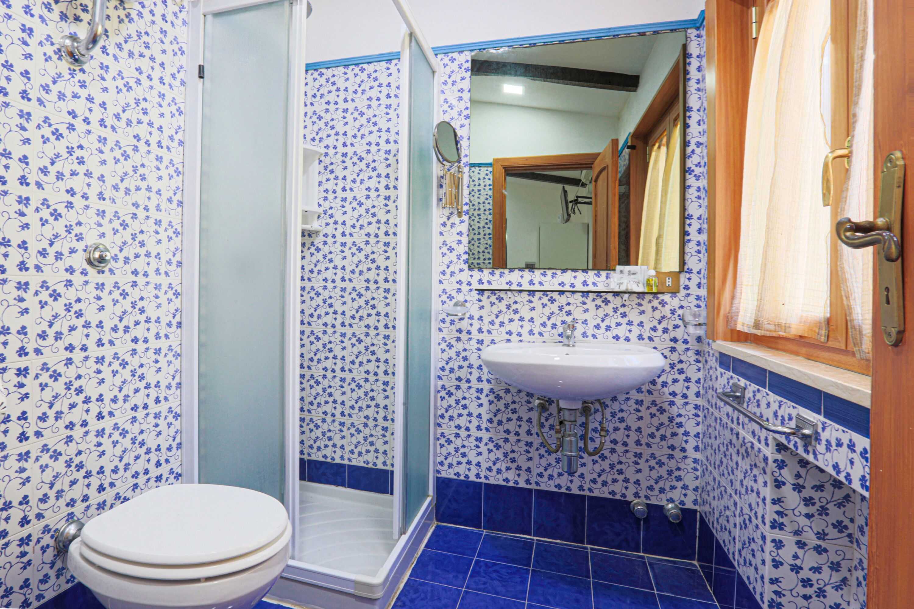 Ein Badezimmer mit Toilette, Dusche, Waschbecken und Spiegel.