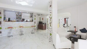 Un moderno vestíbulo de hotel con mostrador de recepción, zona de bar y asientos.