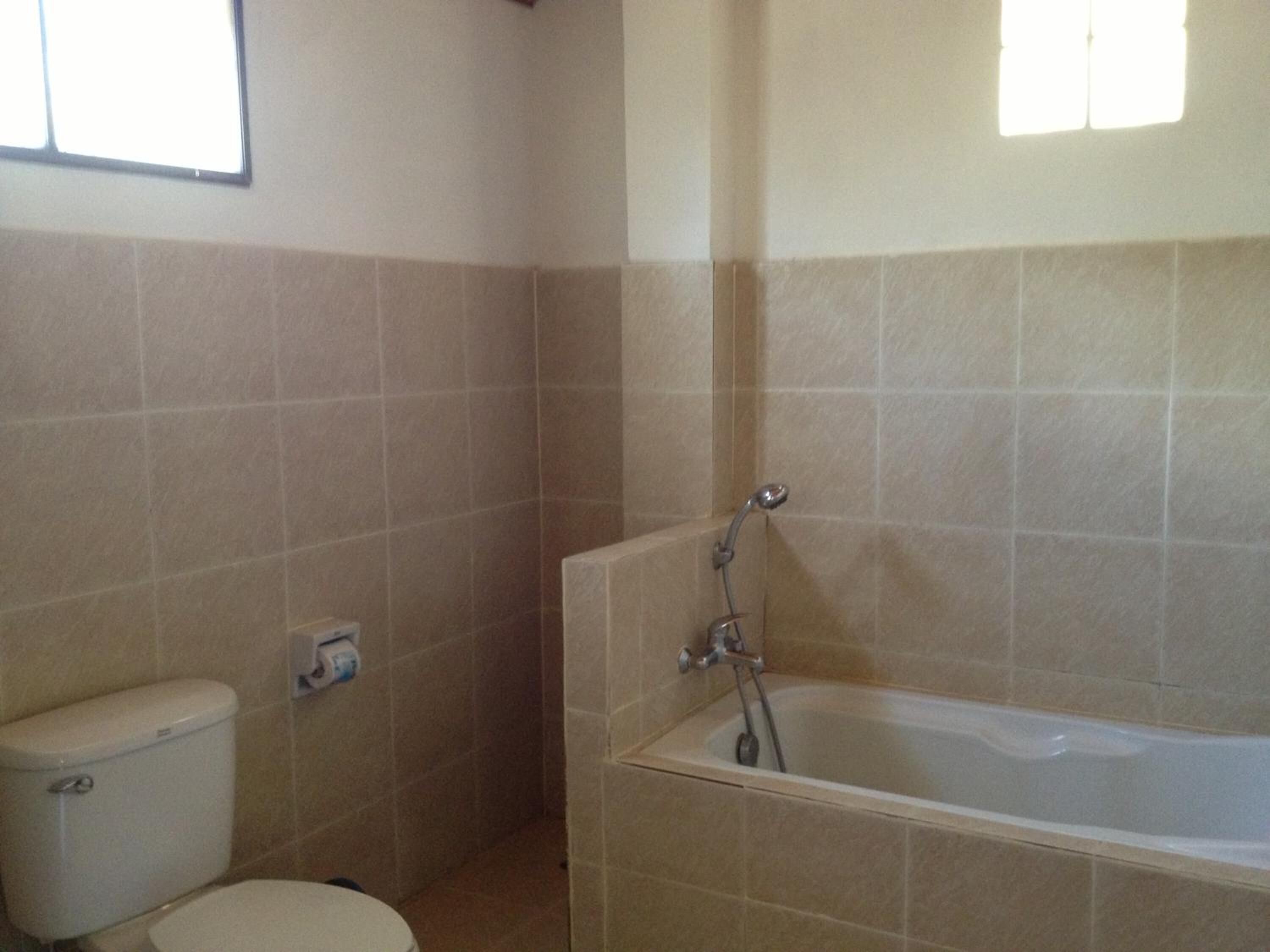 Un baño con inodoro, bañera y ducha.
