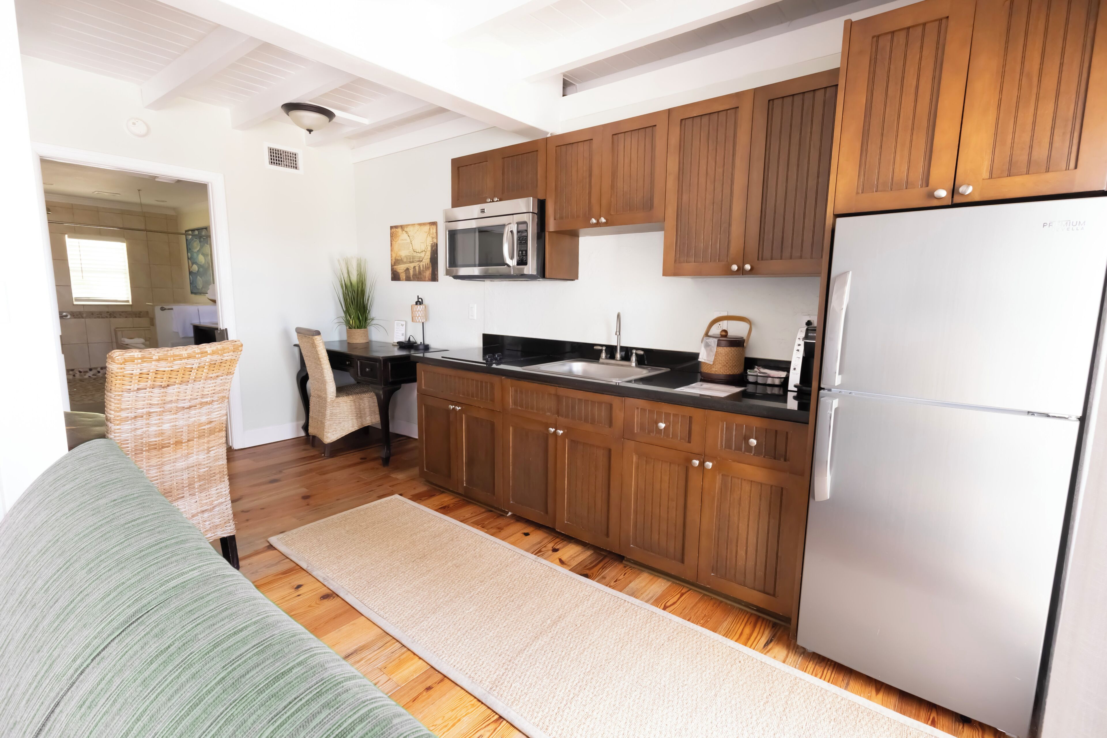 Una cocina moderna con armarios de madera, un refrigerador de acero inoxidable y un microondas.
