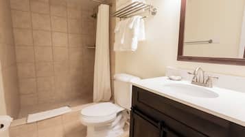 Un baño con ducha, inodoro, lavabo y toallero.
