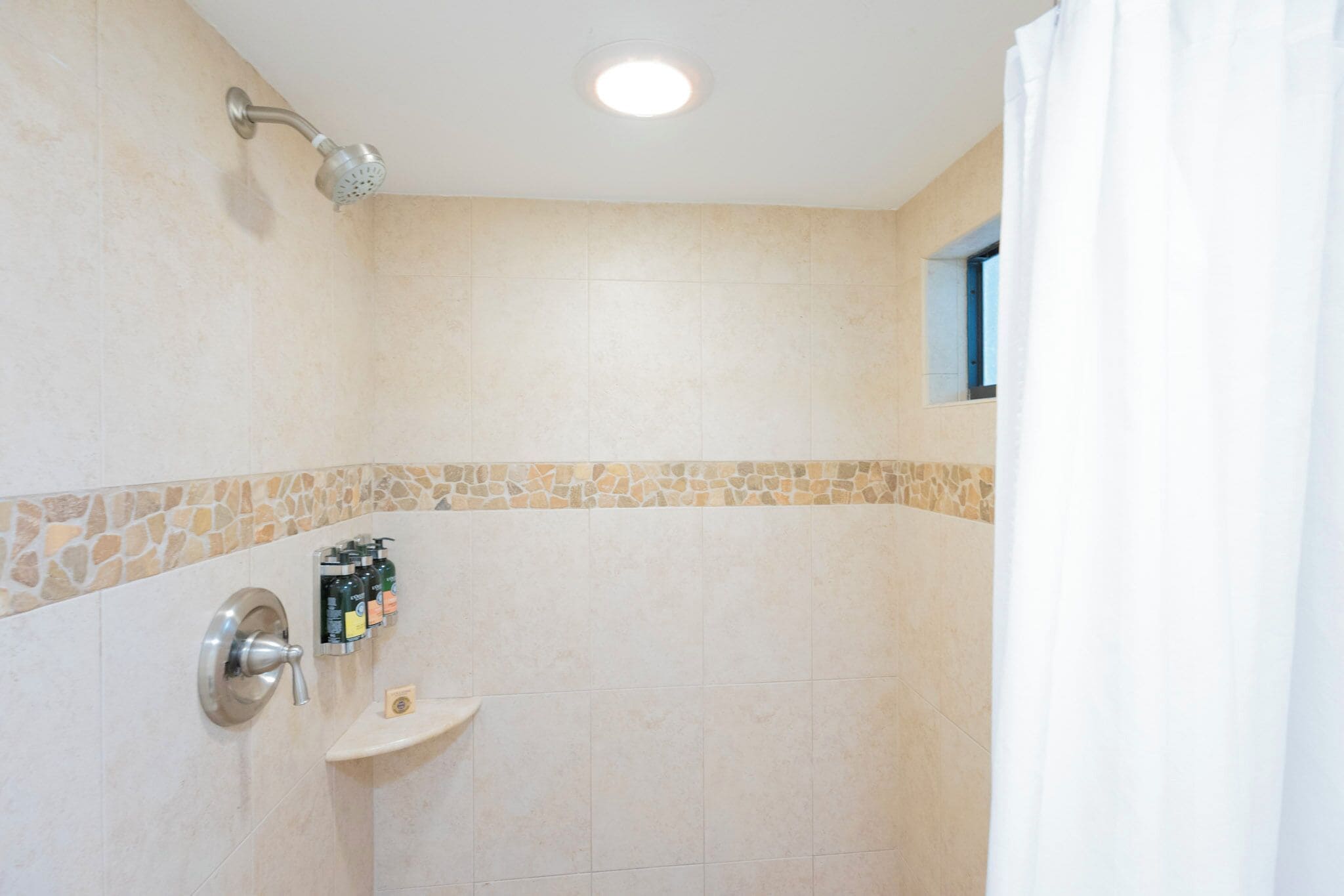 Une salle de bain avec une douche, un lavabo et un porte-serviettes.