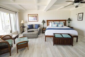 A hotel room with a bed, a sofa, a chair, a nightstand, a lamp, and a window. - Coconut Palm Inn (Tavernier)