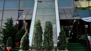 Un edificio moderno con una entrada destacada, un amplio fachada de vidrio y un letrero que dice 'ADRA'.