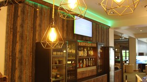 A bar area with wooden walls and a bar counter displaying various bottles. - Hotel Rennsteig (Masserberg)