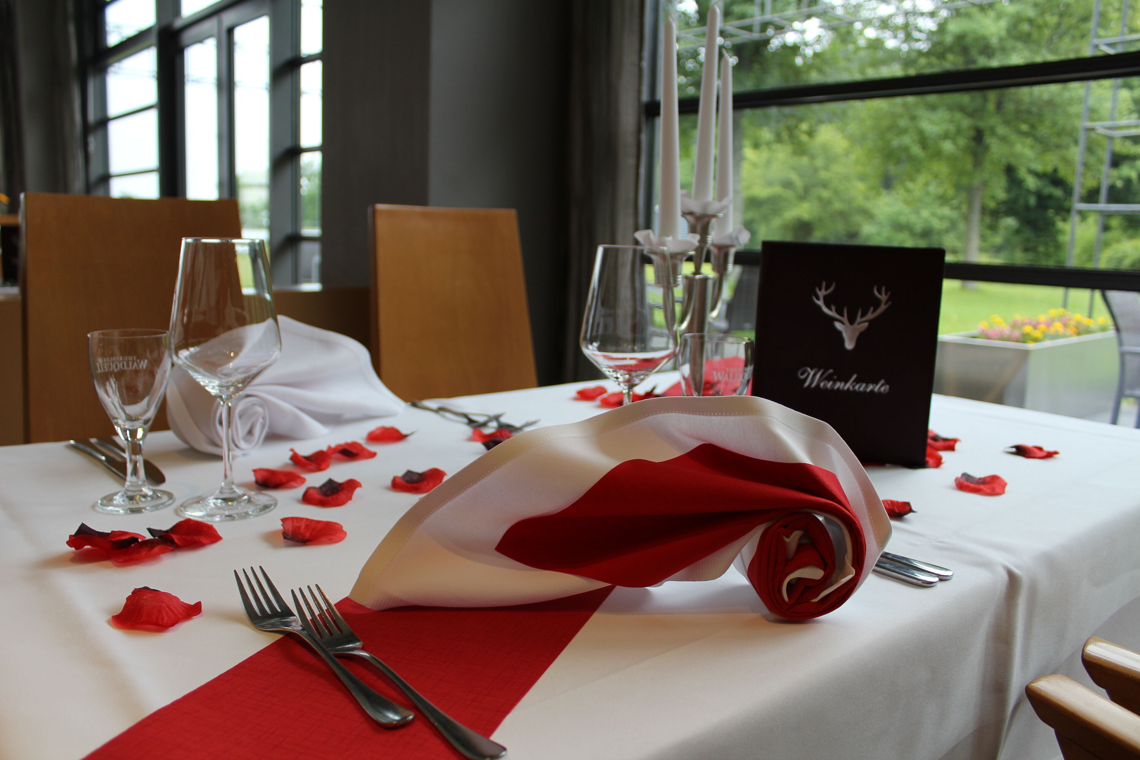 A table set with wine glasses, a folded napkin, and a menu card.
