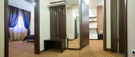 A hotel room with a large mirror, a wardrobe, and a bed.