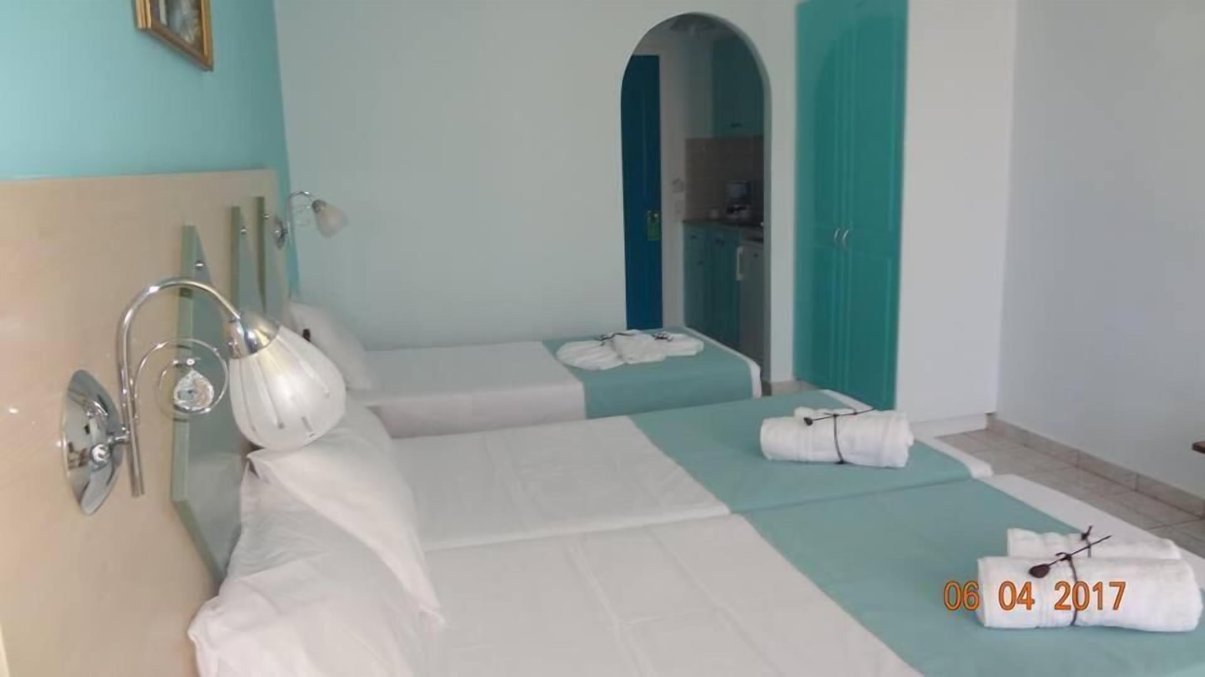 A hotel room with two beds, a bathroom, and a small closet.