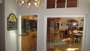 Een moderne keuken met houten kasten, een bar en een eethoek met stoelen en een tafel.
