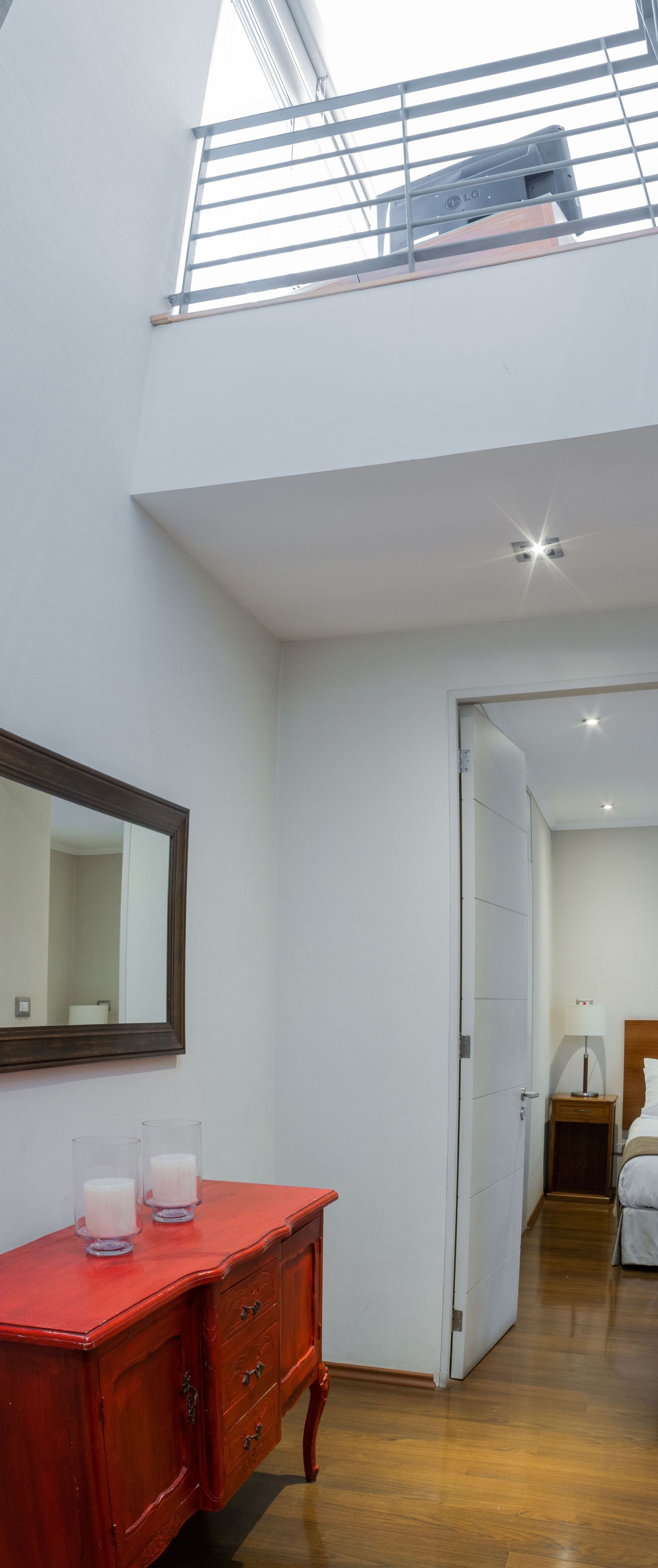 Una camera da letto con una cassettiera in legno, uno specchio e una ventola a soffitto.