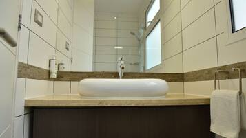 Une salle de bain avec un grand lavabo, des meubles en bois foncé et un miroir au-dessus du lavabo.