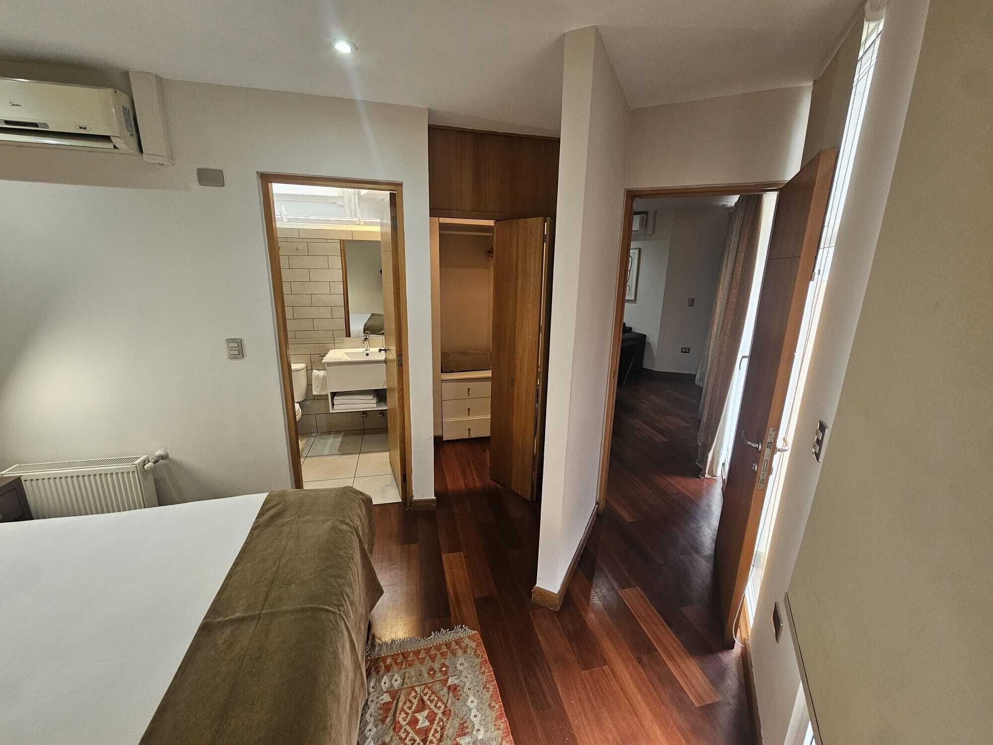 Un dormitorio con una cama, un radiador y suelo de madera.