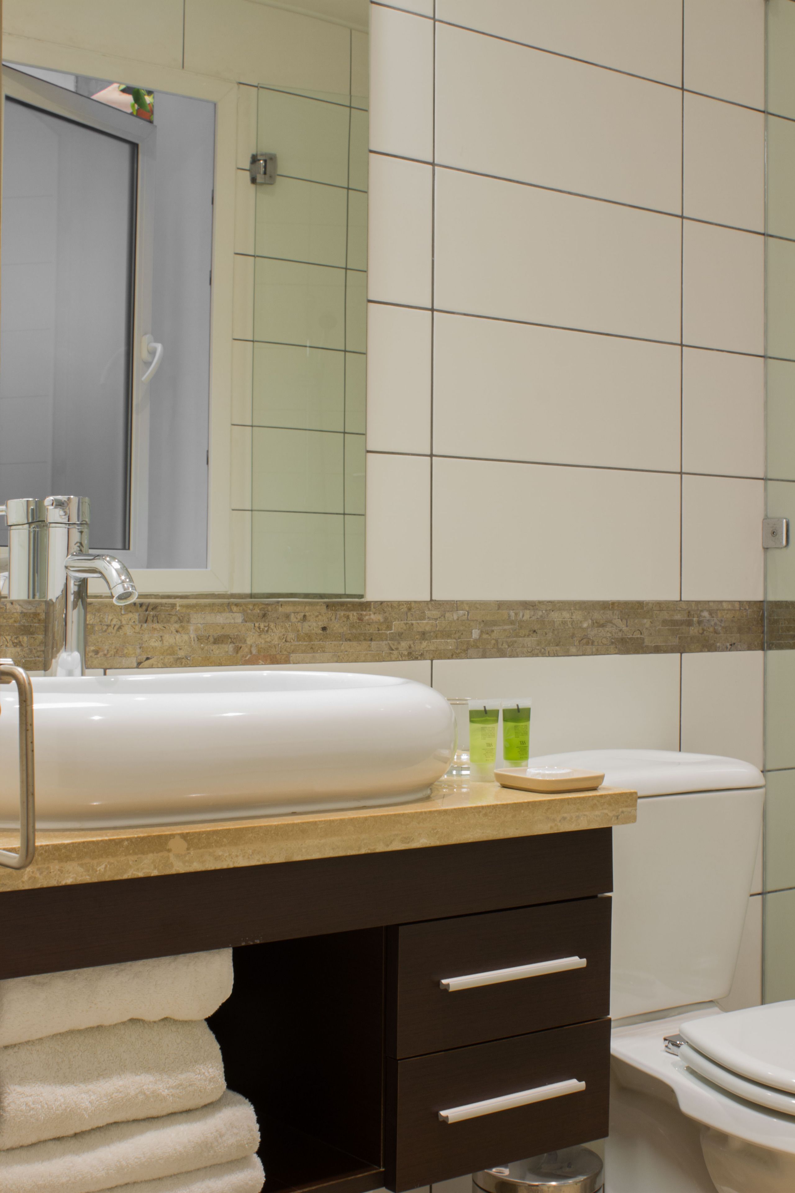 A bathroom with a sink, mirror, and toilet.