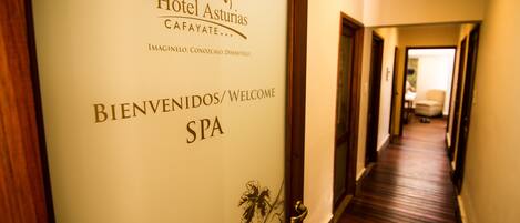 Un couloir avec une pancarte indiquant : « Hôtel Asturias CAFAYATE... BIENVENUE/WELCOME SPA ».