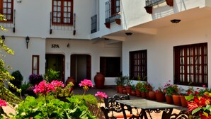 Un patio con una mesa y sillas, plantas en macetas y un edificio con un letrero que dice "SPA".