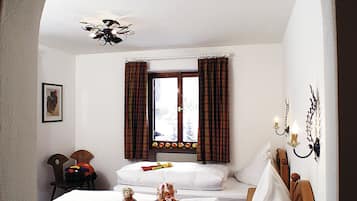 Classic design meets comfort in this stylish room with a double bed, wooden headboard, and elegant candelabra.