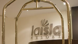 A reception desk with a modern design, featuring a black and white color scheme and a logo that reads "laisla RESORT". - La Isla Resort (Pontecagnano Faiano)