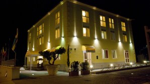 A multi-story building with illuminated windows and a well-lit entrance. - La Isla Resort (Pontecagnano Faiano)