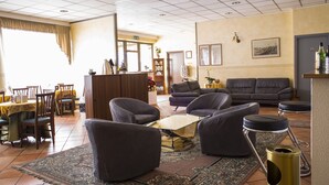Ein geräumiges Wohnzimmer mit einer Sofagarnitur, einem Couchtisch und einem Essbereich mit Stühlen und einem Tisch.