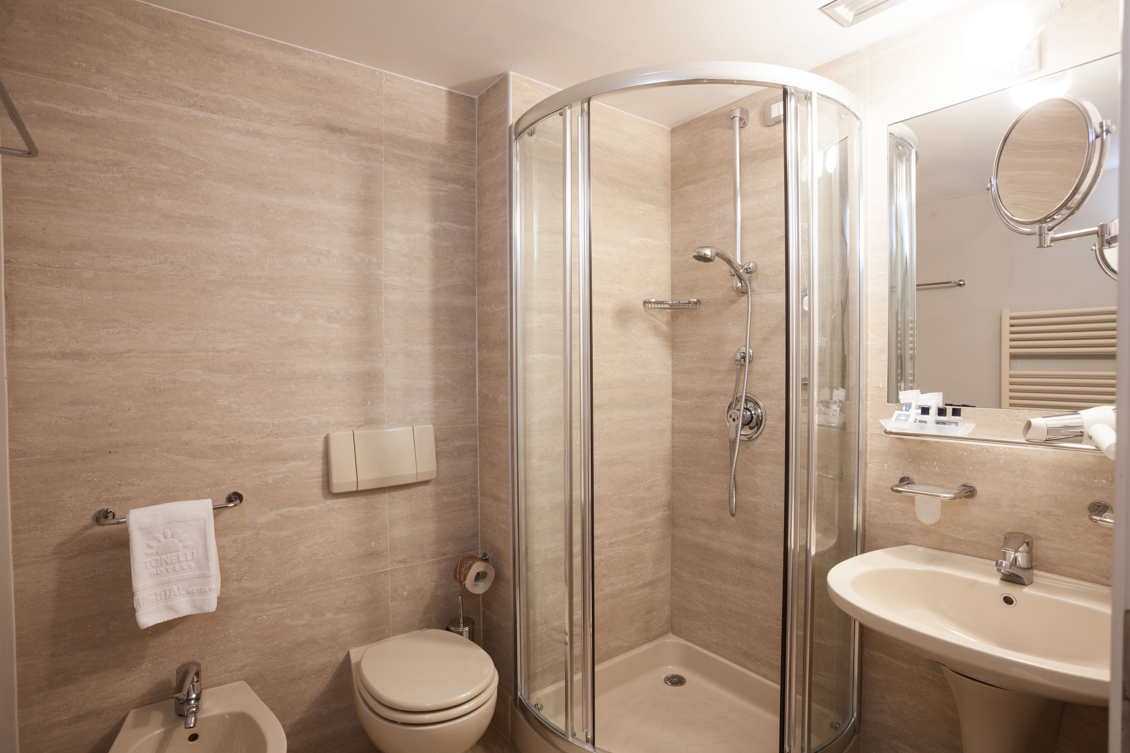 A modern bathroom with a glass-enclosed shower, a sink, and a toilet.