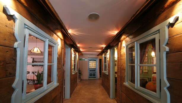 A wooden hallway with large windows and a tiled floor. - Hotel Risnjak (Delnice)